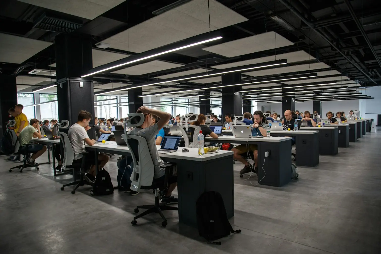 Large open-plan office with rows of people working at computers