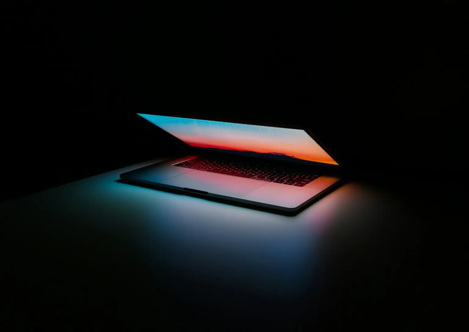 Laptop glowing in a dark room