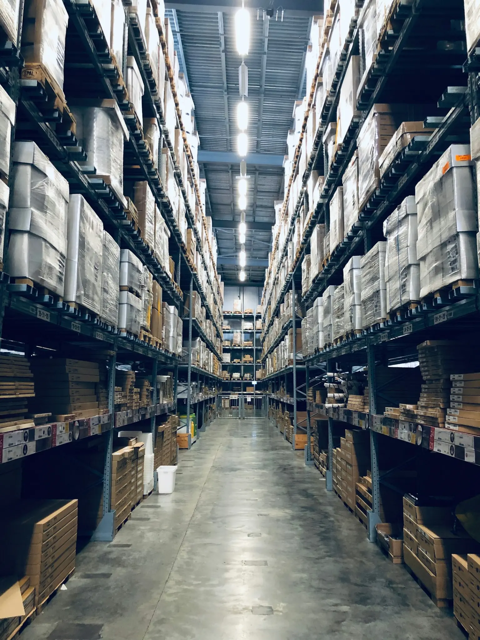 Warehouse aisle between tall shelves of stock
